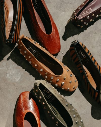 Various pairs of women's flats in earth tones.